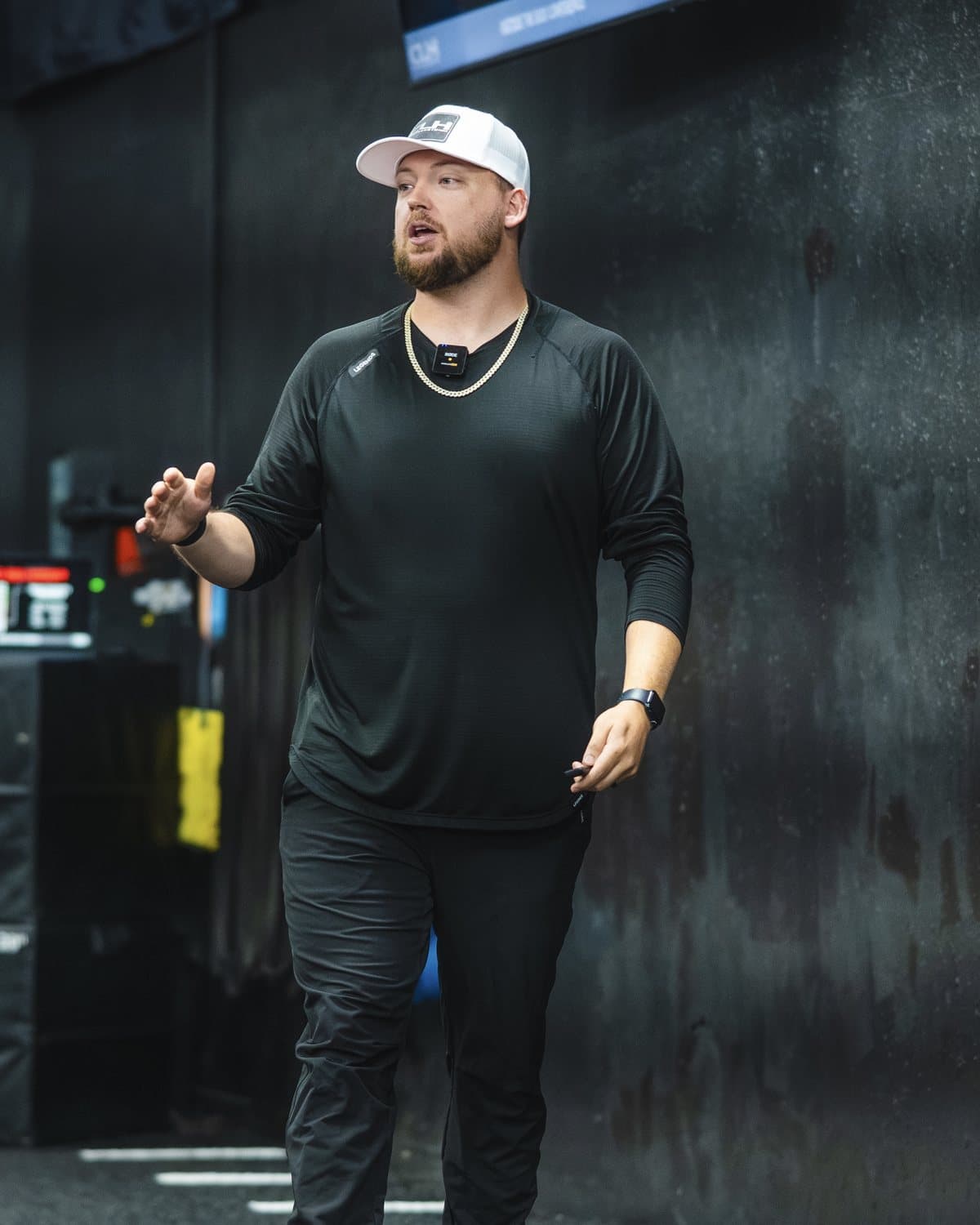 Cody Hughes coaching on a weight room floor
